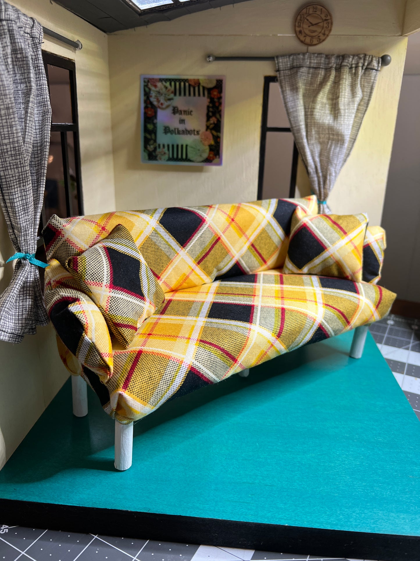 handmade Barbie doll couch, in a dollhouse setting for scale, includes two pillows by Panic in Polkadots. Bright plaid fabric in yellow, with red, white and black