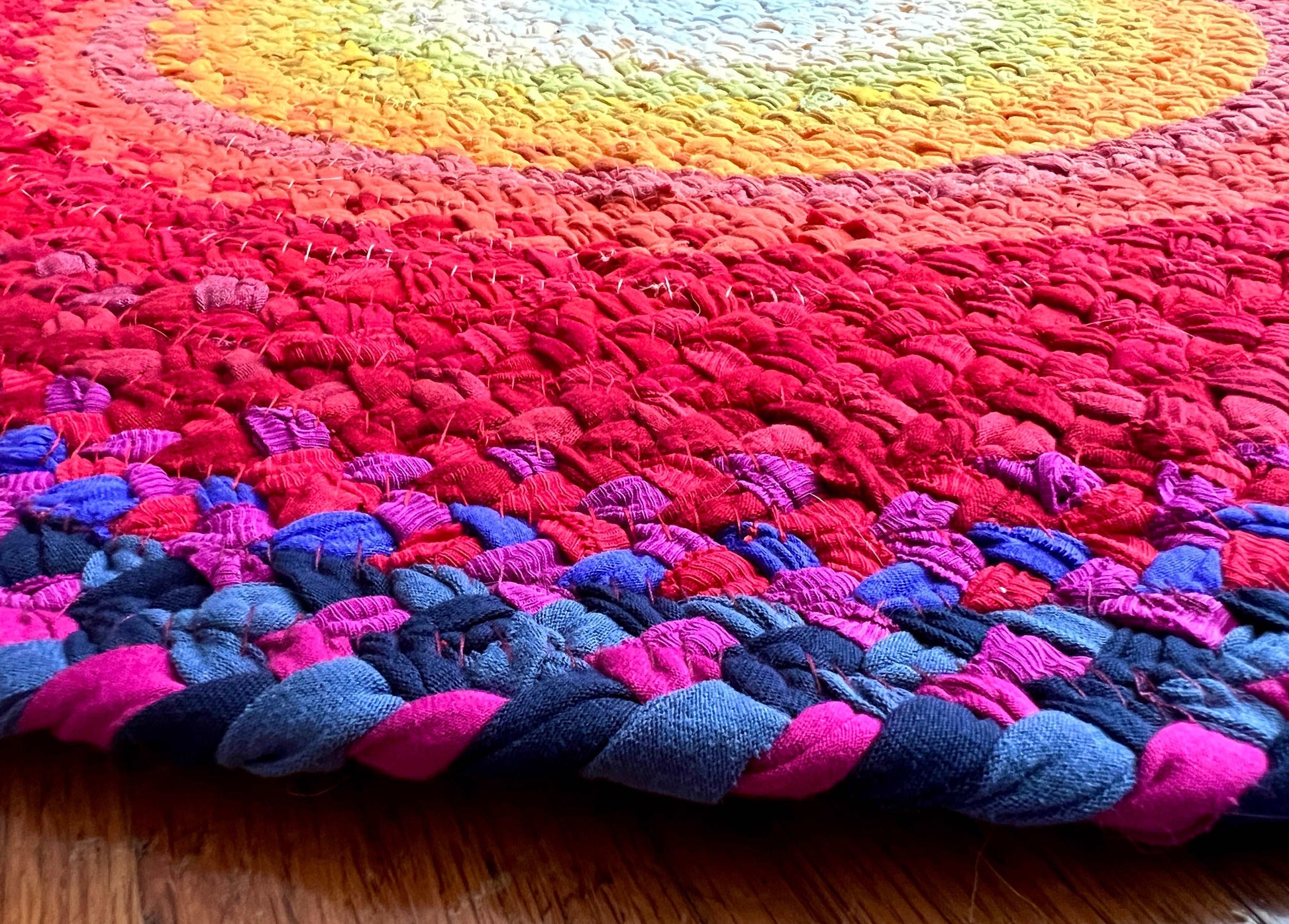 closeup side view of the underside of the rug, showing colorful stitches