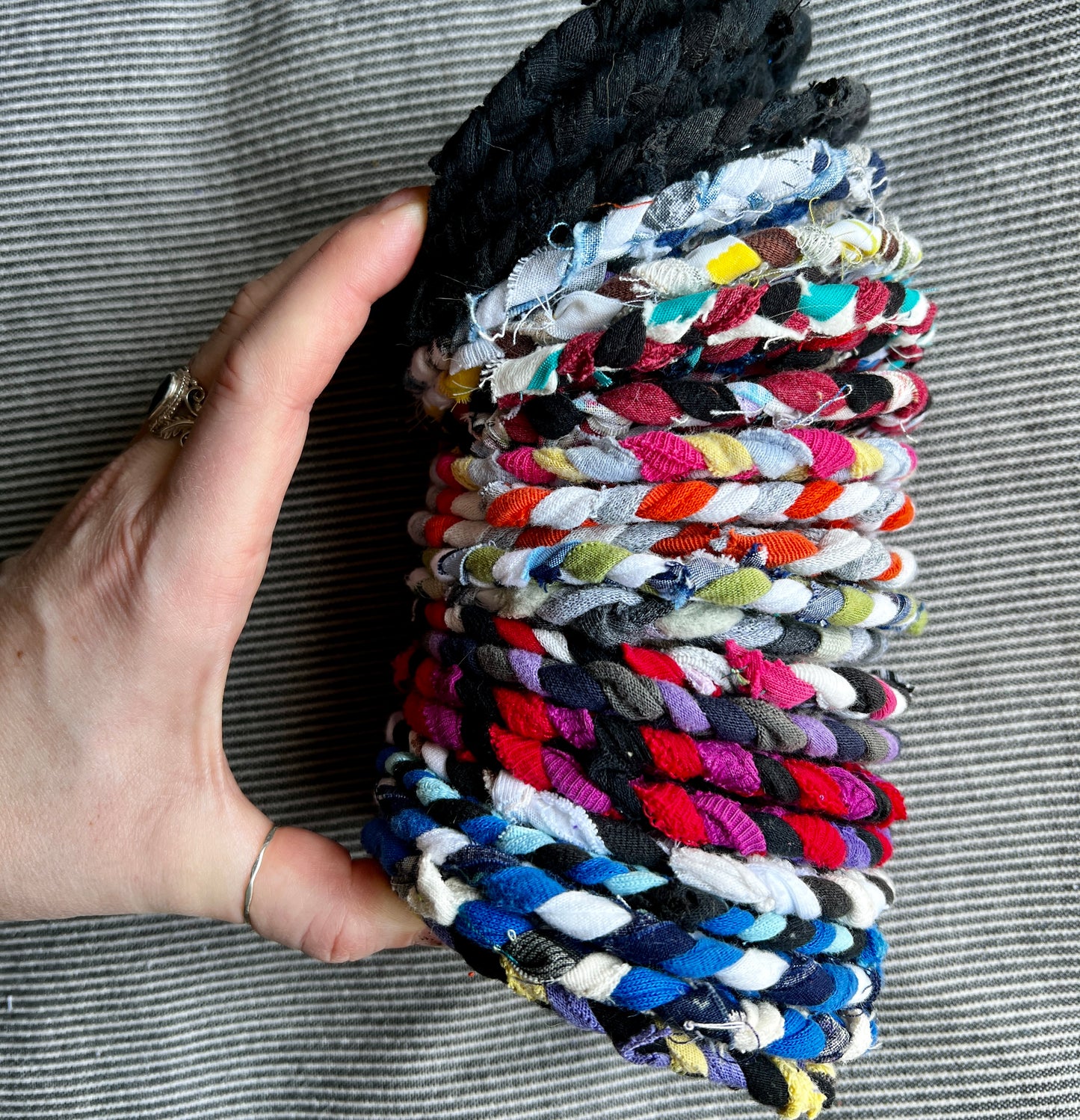 Hand braided and Handsewn coaster singles, held in a stack for scale