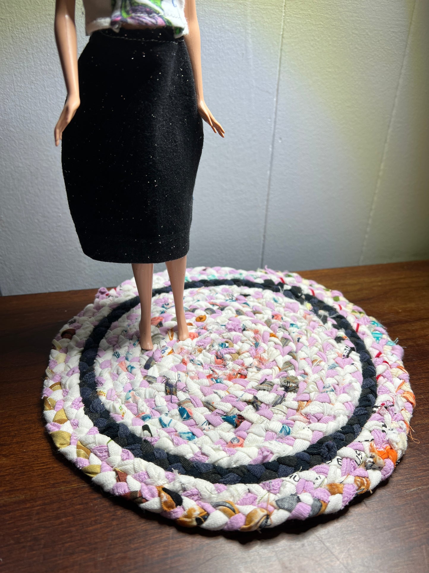 view of miniature rug in a room box, with Barbie standing atop the pink white rug for scale and display ideas