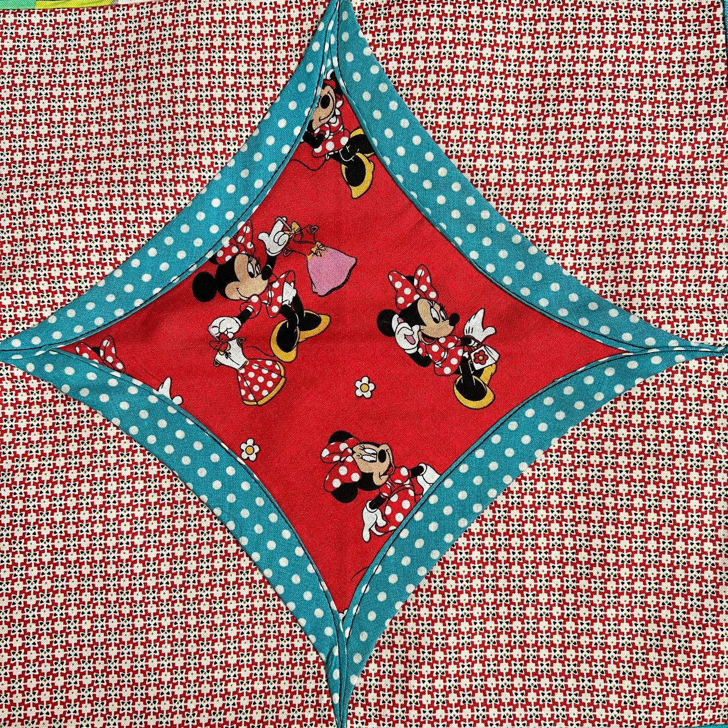 Minnie and Mickey Mouse fabric square, surrounded by blue polkadots, then red pattern fabrics