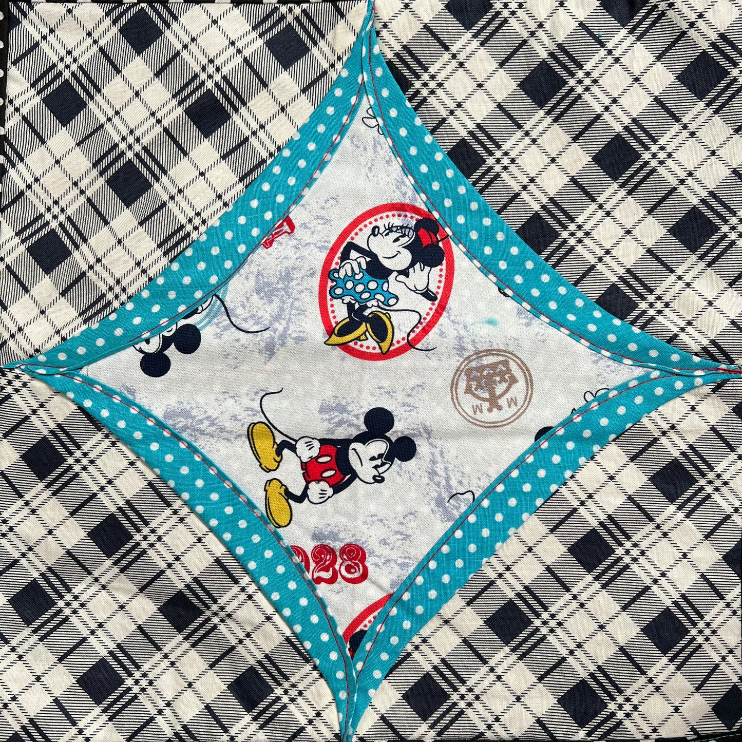 Minnie and Mickey Mouse fabric square, surrounded by blue polkadots, then black and white plaid fabrics