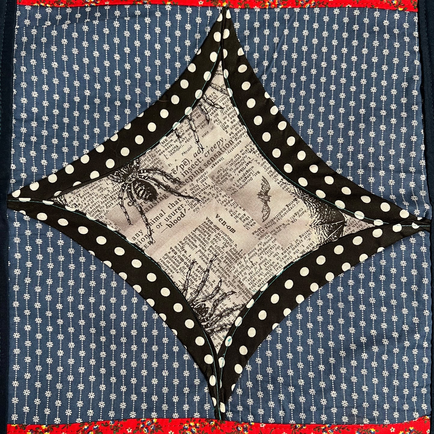 spooky halloween fabric square, surrounded by black and white polkadots, then blue floral linear fabrics.