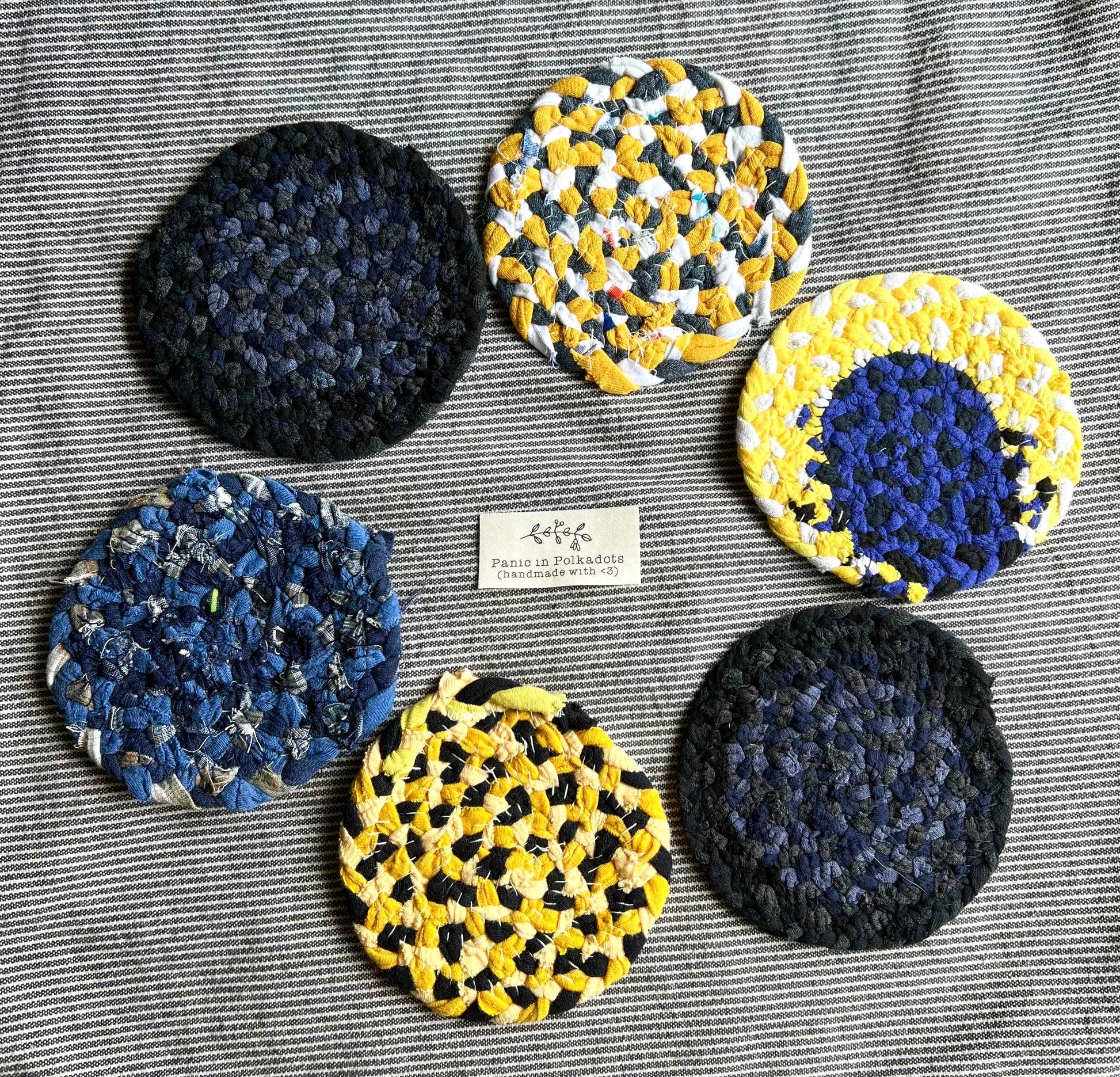 Mini rug coaster set of six, in a circle formation, with a Panic tag in the middle, aerial view