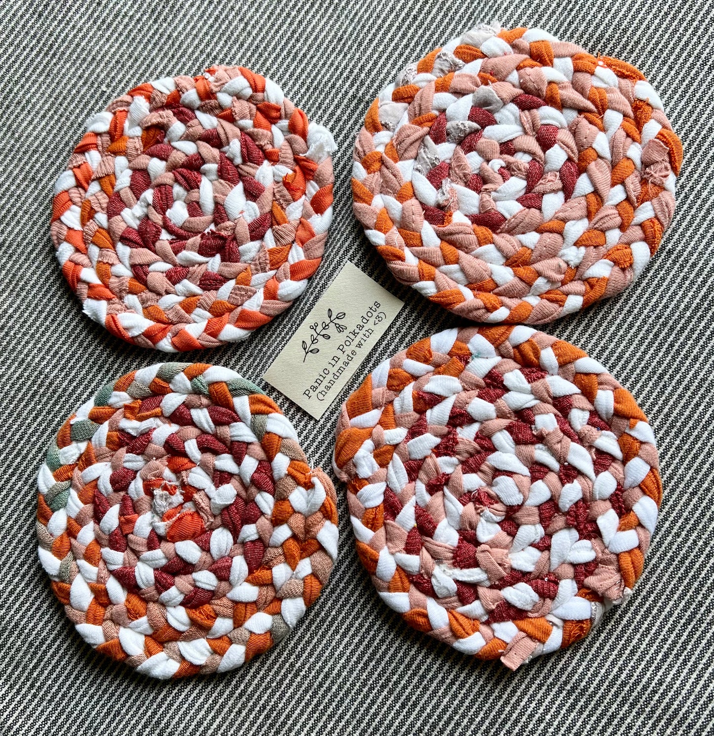 Mini rug coaster set of four, in a diamond formation, with a Panic tag in the middle, side view