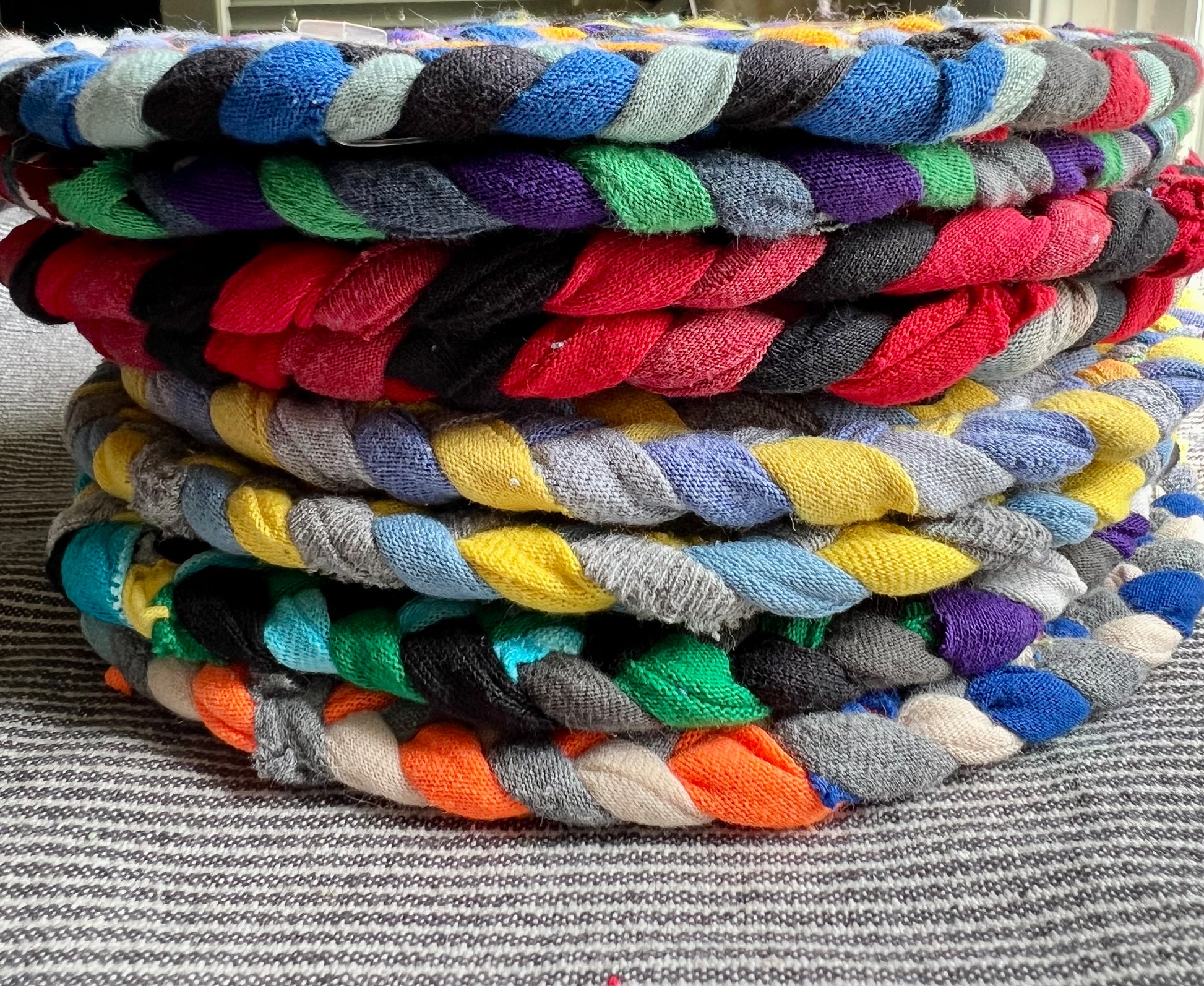 A stack of colorful trivets, side view.