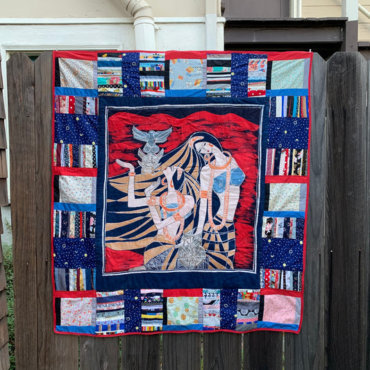 Deities and Totems quilt, in bright red and blue, with gold accents, a scrappy stripe border, with vintage butterflies all around the edge