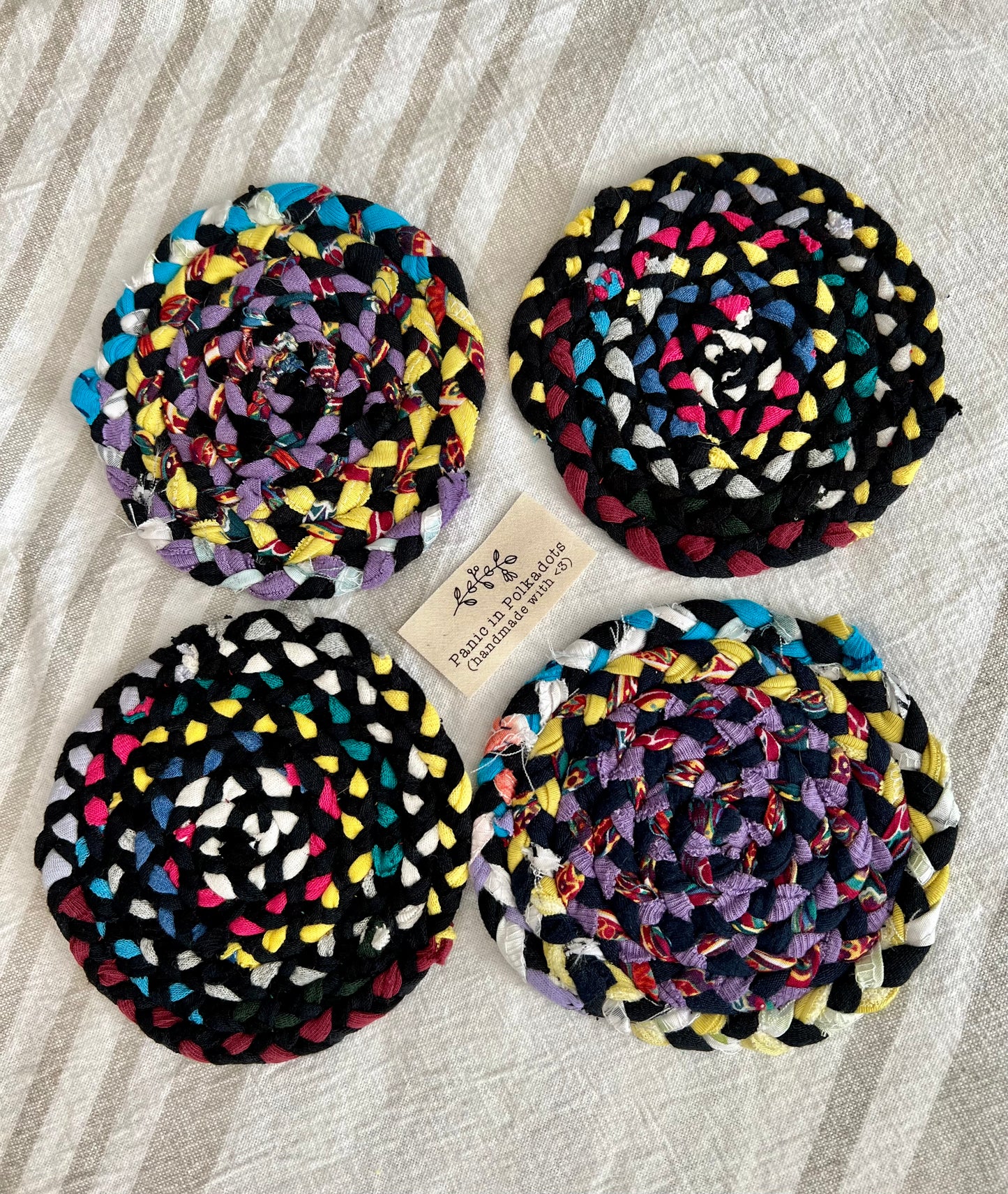 Mini rug coaster set of four, in a diamond formation, with a Panic tag in the middle, aerial view