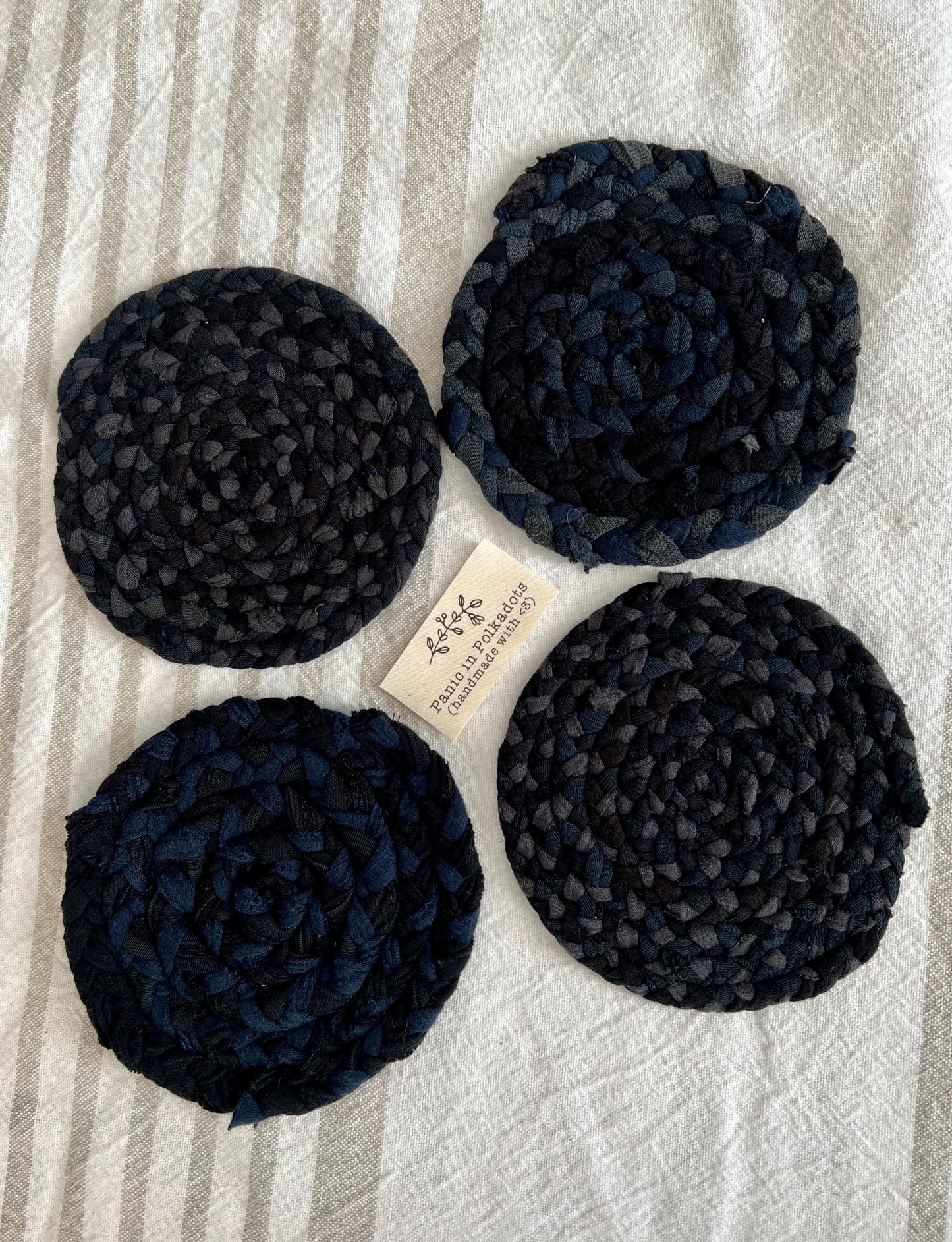Mini rug coaster set of four, in a diamond formation, with a Panic tag in the middle, side view