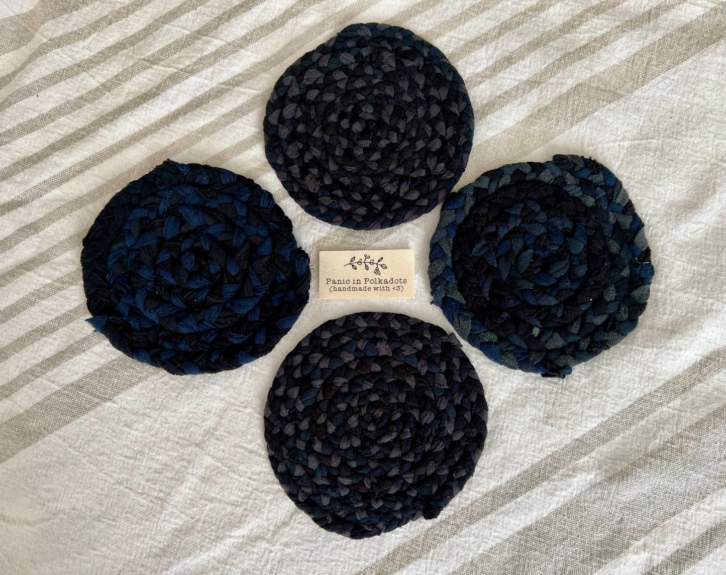 Mini rug coaster set of four, in a diamond formation, with a Panic tag in the middle, aerial view