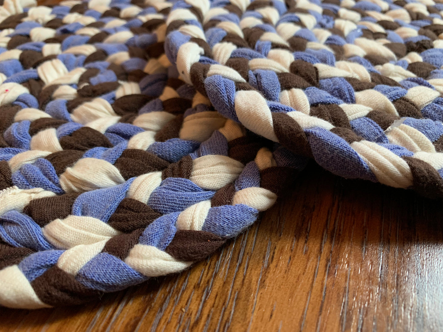 Close up, side view, showing detail in edge of trivets on wood surface.