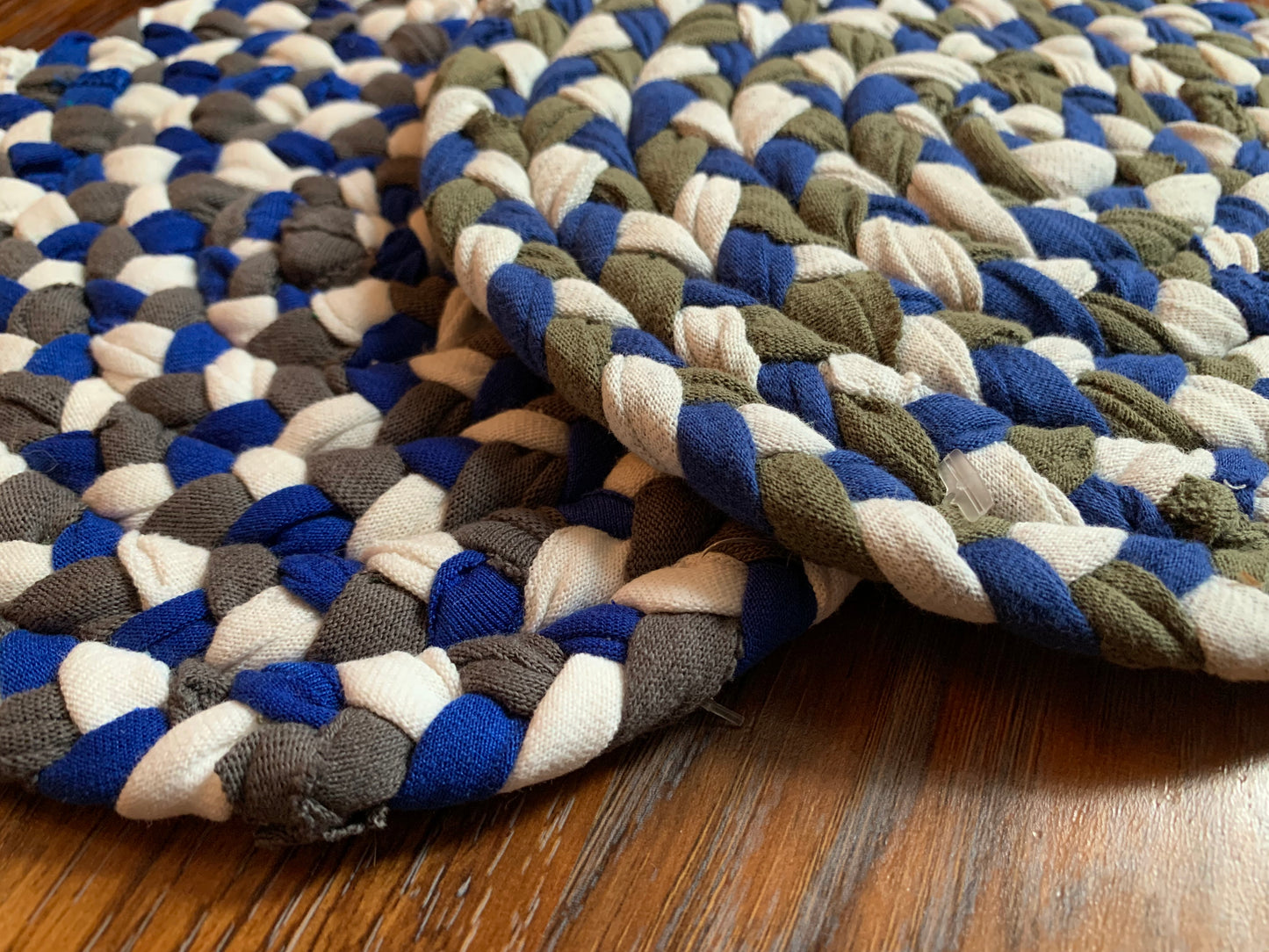 Close up, side view, showing detail in edge of trivets on wood surface.