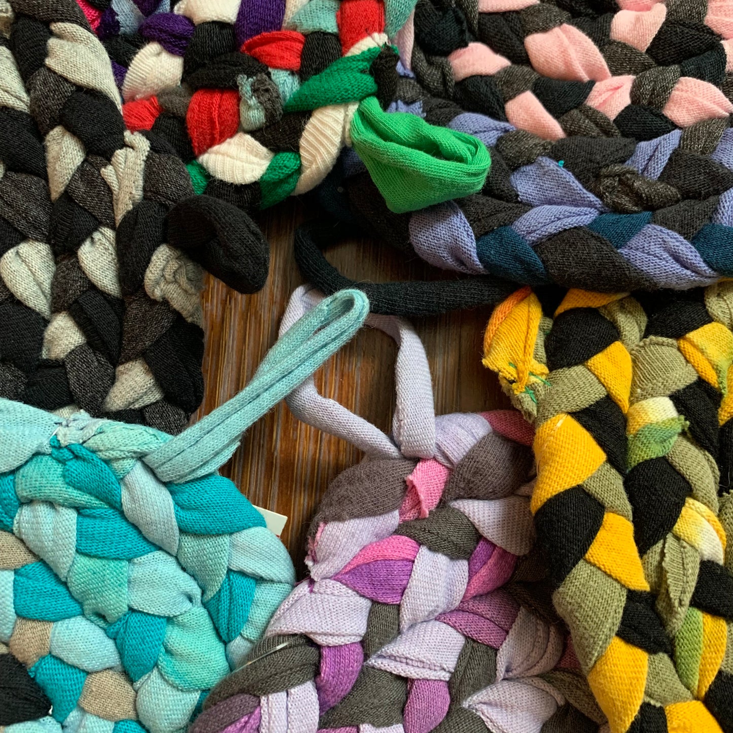 closeup of a group of colorful potholders, with loops toward the center. 