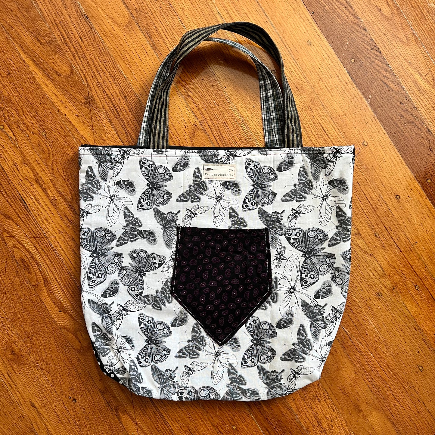 back view of tote bag, with a necktie pocket and a Panic in Polkadots label