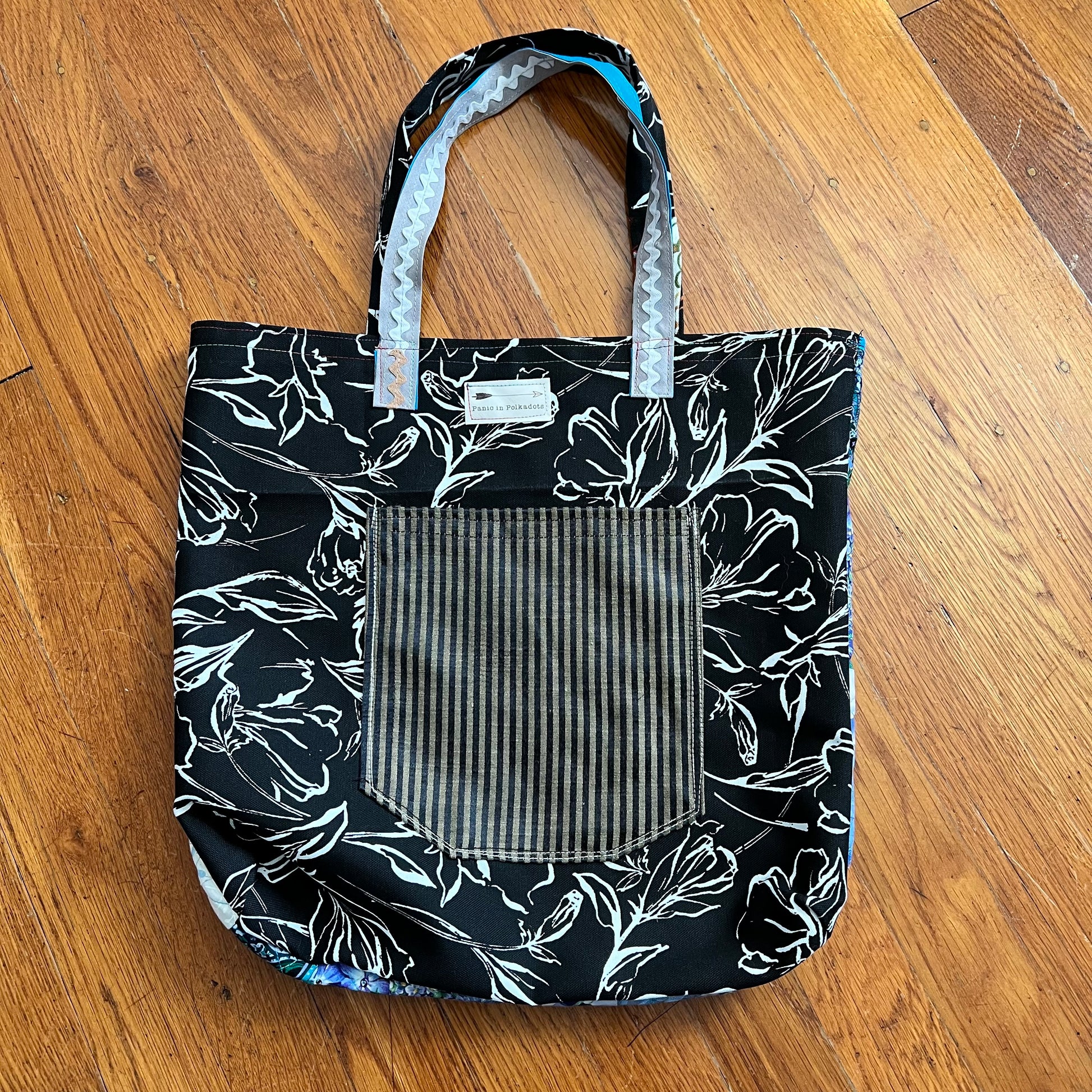 back view of tote bag, with a striped pocket and a Panic in Polkadots label