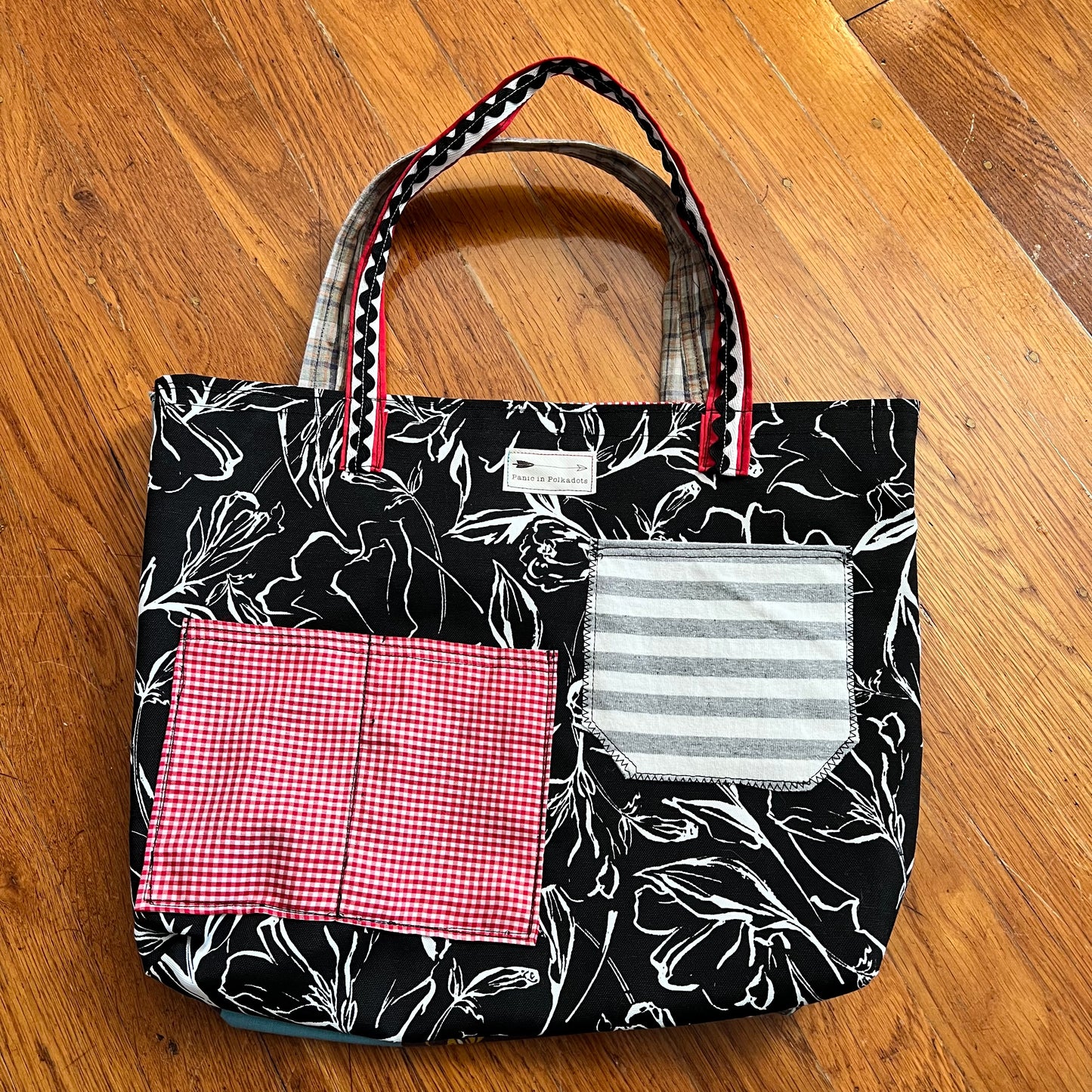 back view of tote bag, with two striped and gingham pockets and a Panic in Polkadots label