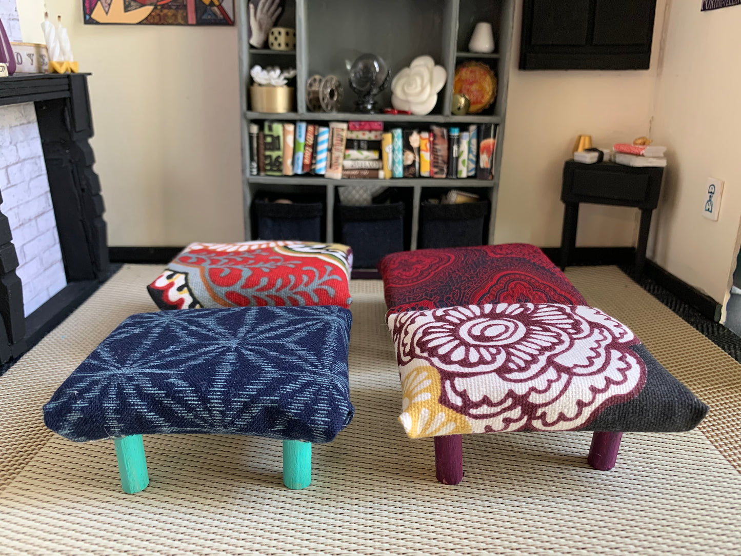 four ottomans, in a dollhouse room for scale and styling