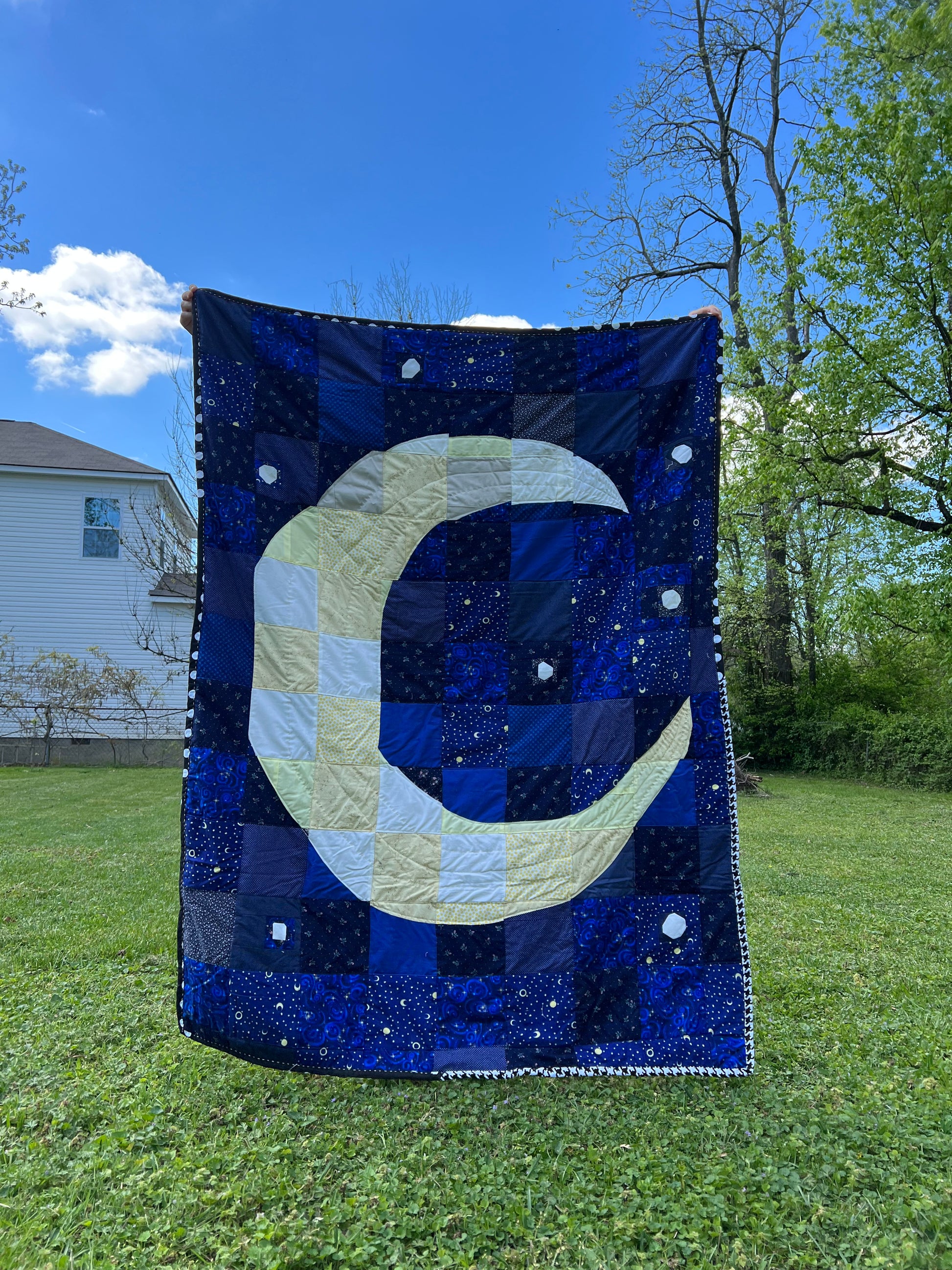 a crescent moon has been created from patchwork squares, and with fabric scraps and vintage yardage
