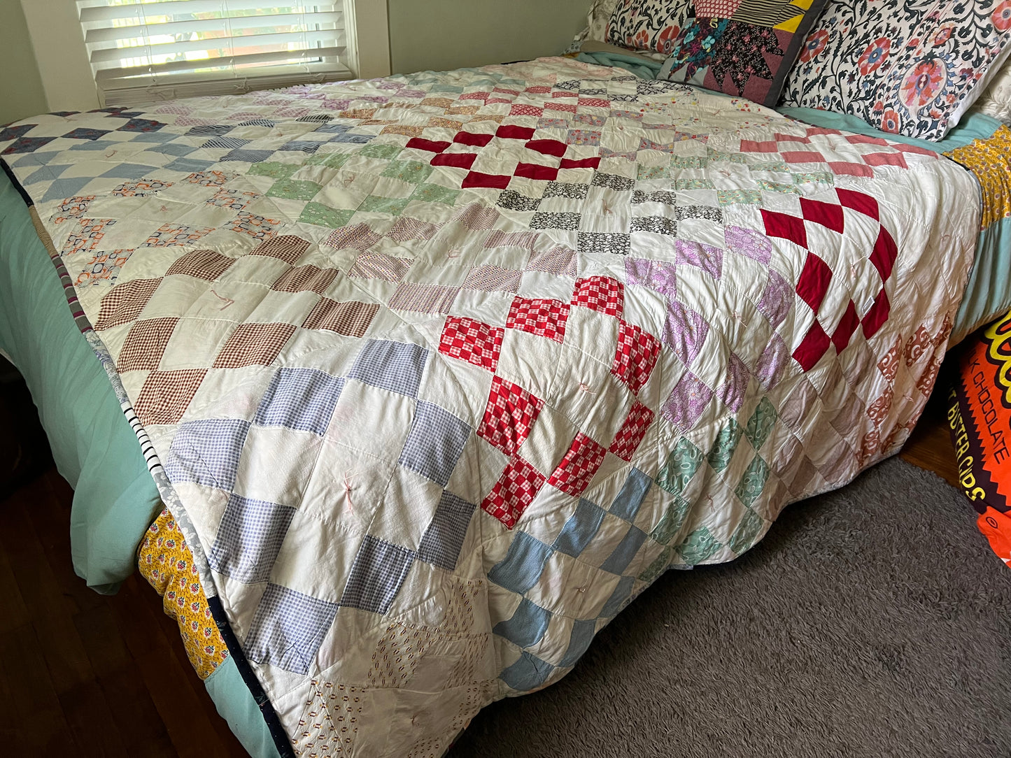 Vintage Quilt on top of a queen sized bed, it hangs down over the sides, and is very lovely