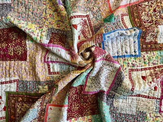 Kantha hand-stitched vintage feedsack quilt. spiral aerial view. the middle is scrunched together to show texture