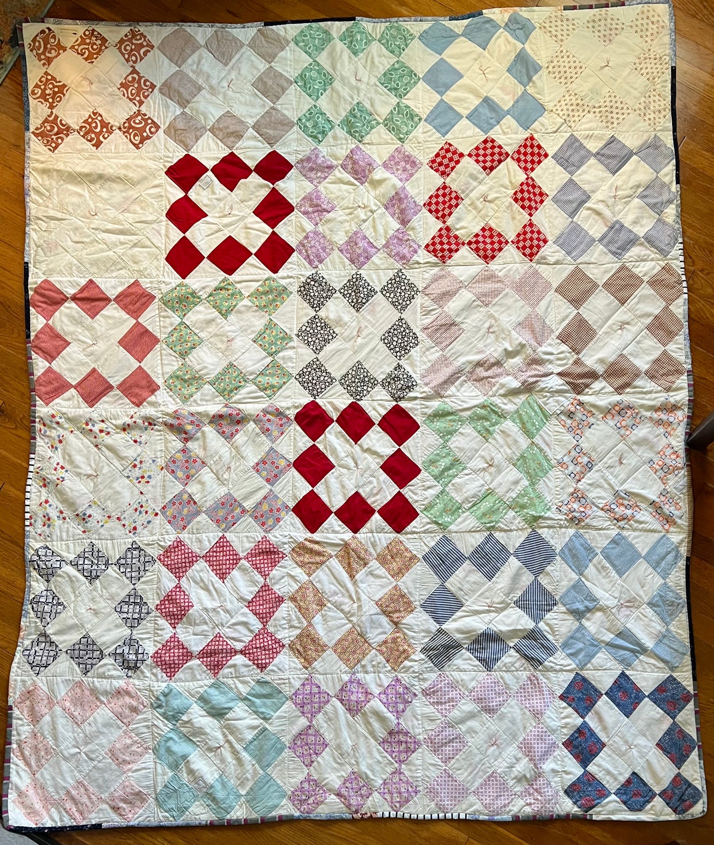 aerial view of this twin sized, lightweight quilt, against a wood floor background