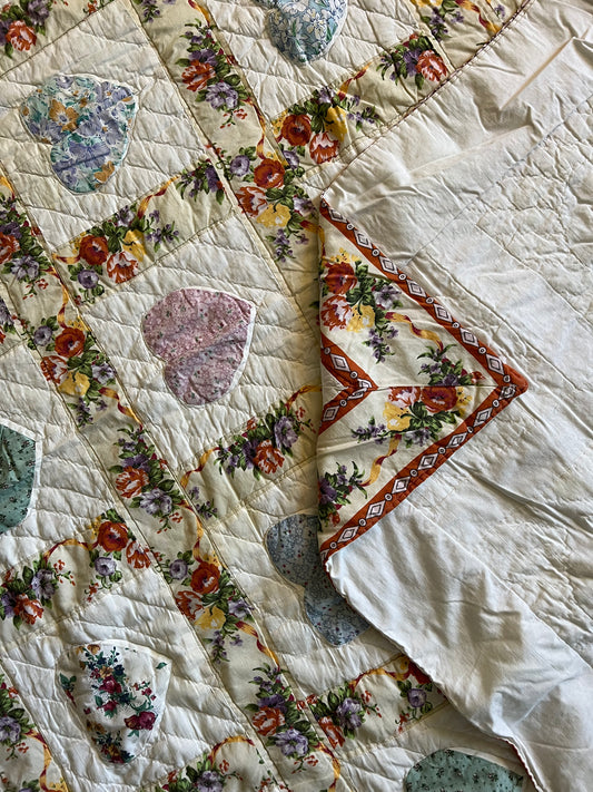 A quilt, folded a few times, with the corner folded over the backing and then the backing folded over the front