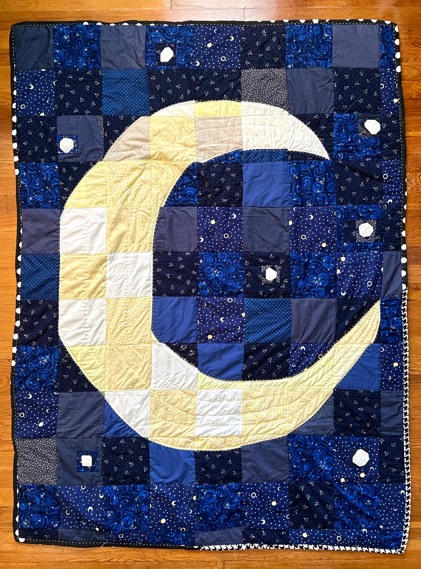 aerial view of moon quilt as it lays on a wood floor