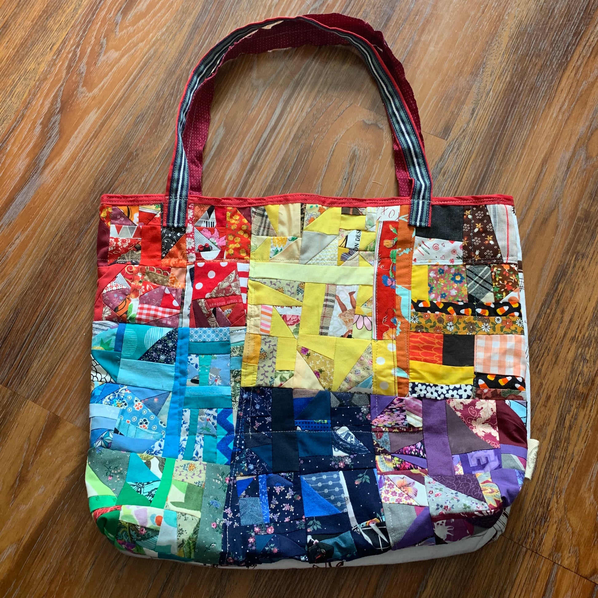 aerial view of rainbow panels tote bag, on a wood floor background