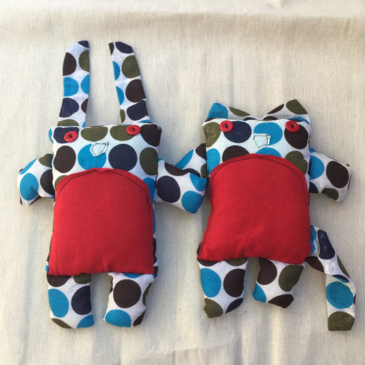 A plushie bunny and a plushie kitty, side by side. They are created out of a vintage polkadot fabric of blue, navy, and brown. They have red button eyes, red tshirt fabric tummy, and little noses sewn on. A very cute duo!