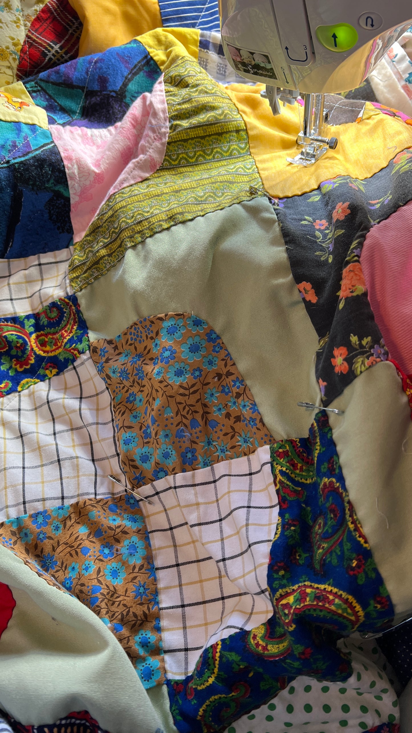 Closeup of retro neon snowballs quilt, on sewing machine, with pins in between each square