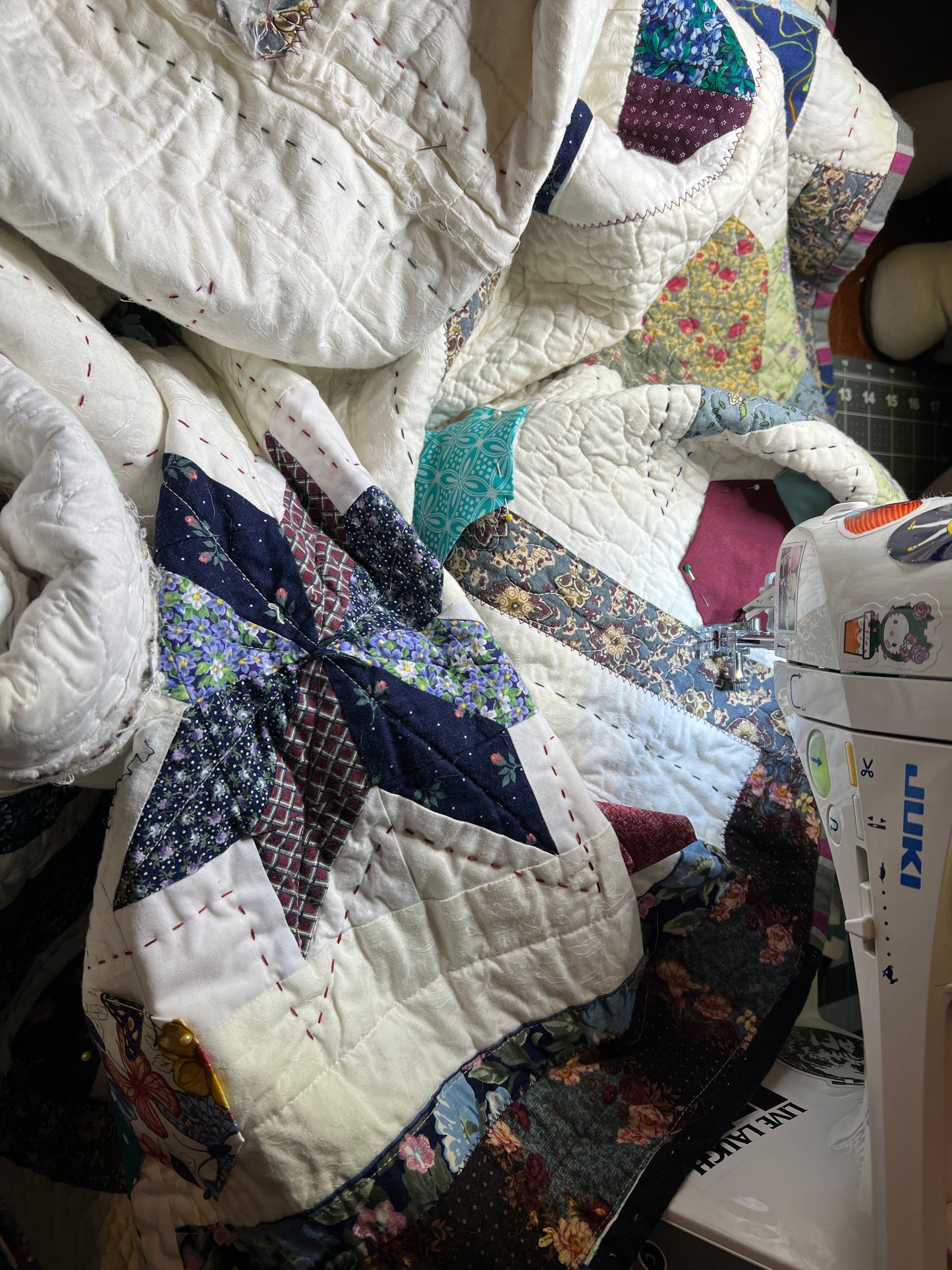 A quilt with eight point stars and quilted hexies, as a work in progress on the sewing machine