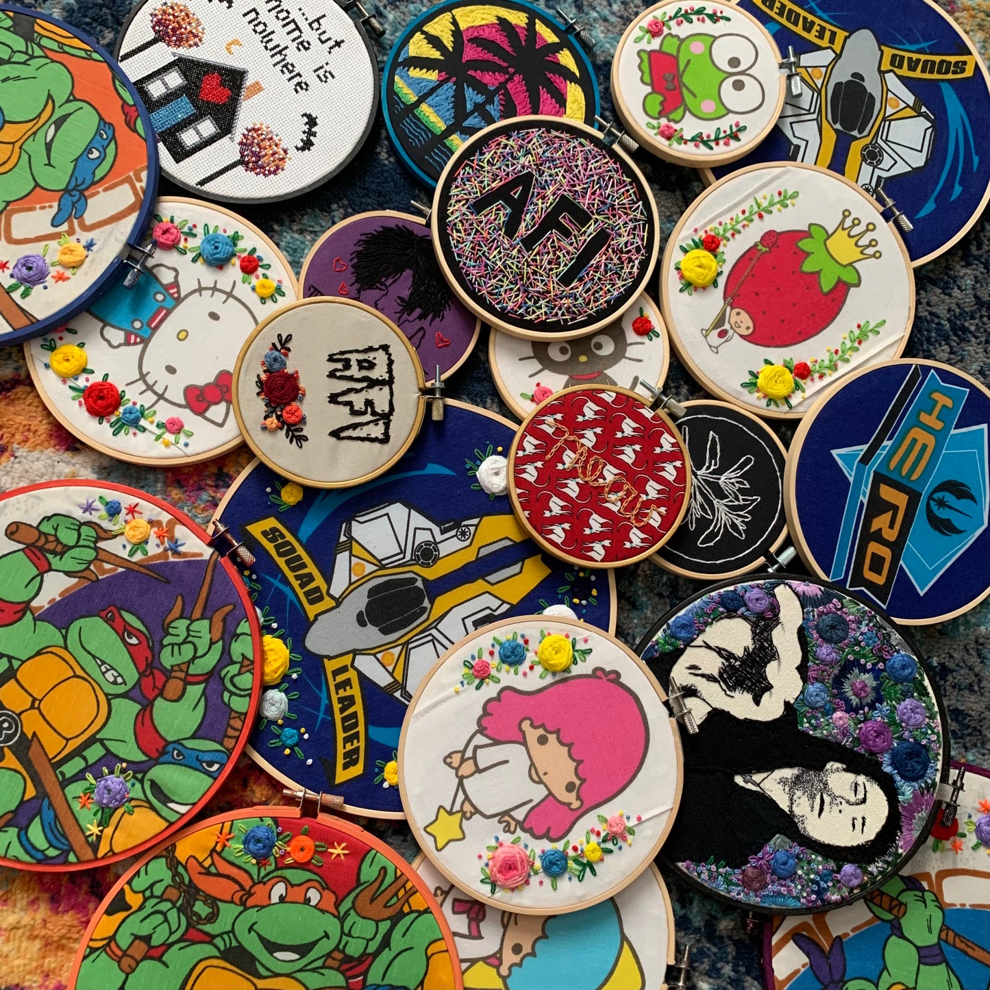 A group of colorful embroidery hoops, all in a loose pile on top of others