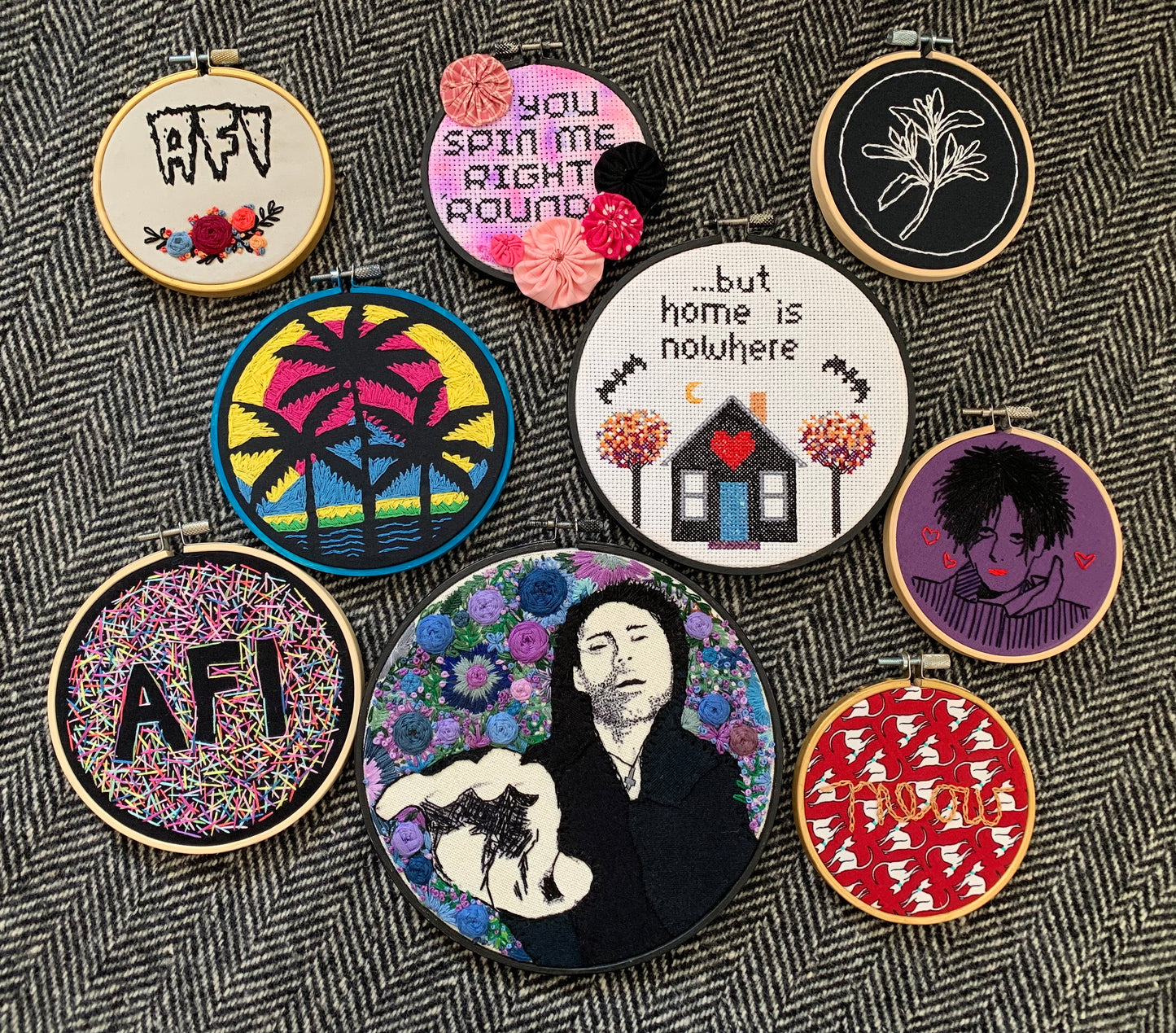 a group of AFI Davey Havok Robert Smith Blaqk AUdio embroidery hoops