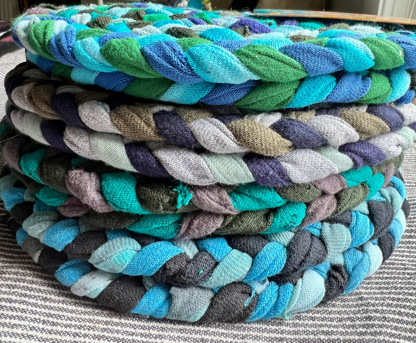 a stack of blue and green trivets or potholders, showing thickness