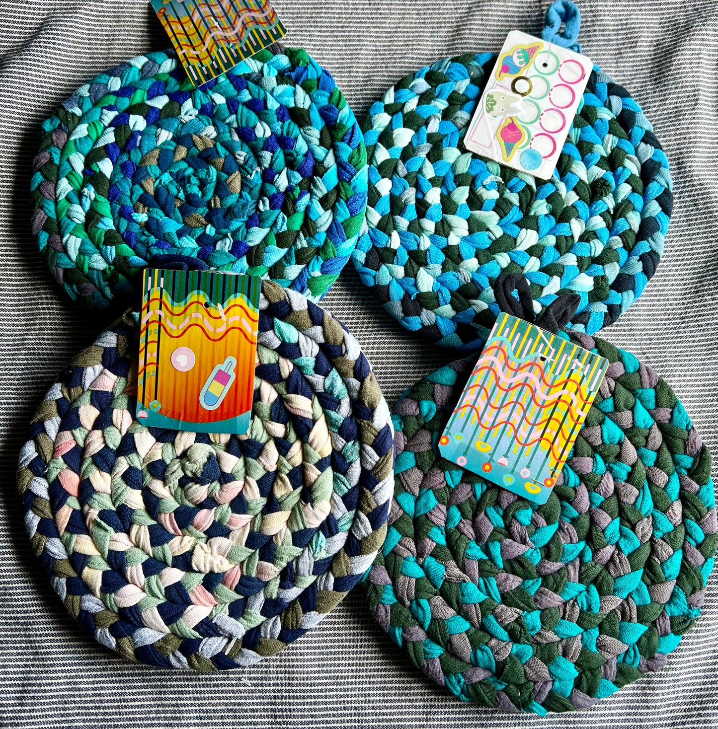 a group of trivet potholder sets, against a grey background, flat lay