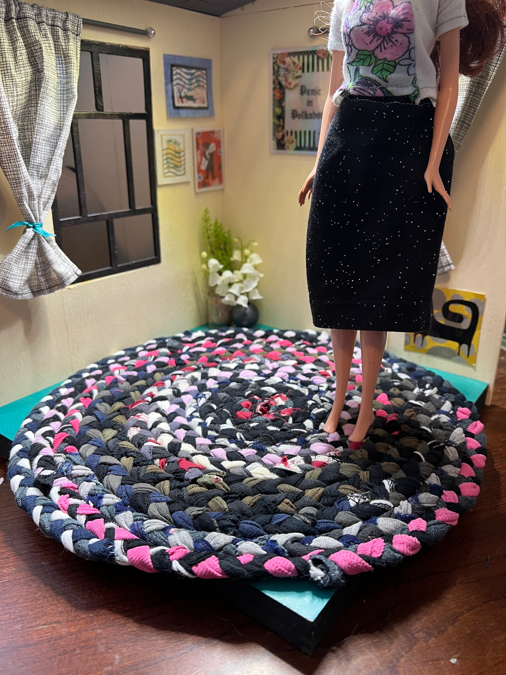 view of miniature rug in a room box, with Barbie standing atop the 11" pink black white rug for scale and display ideas