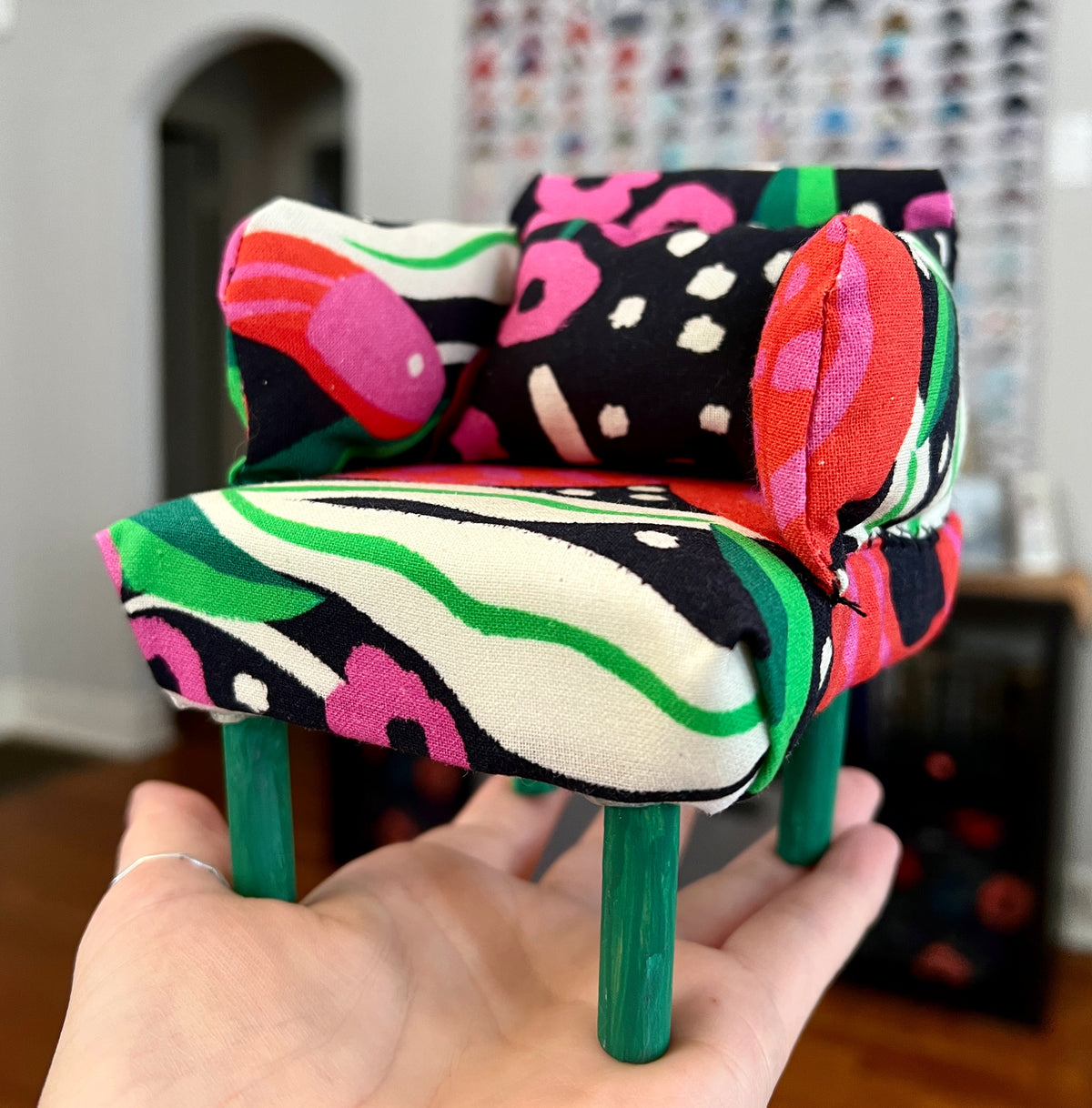 A dollhouse chair, crafted from upcycled materials.