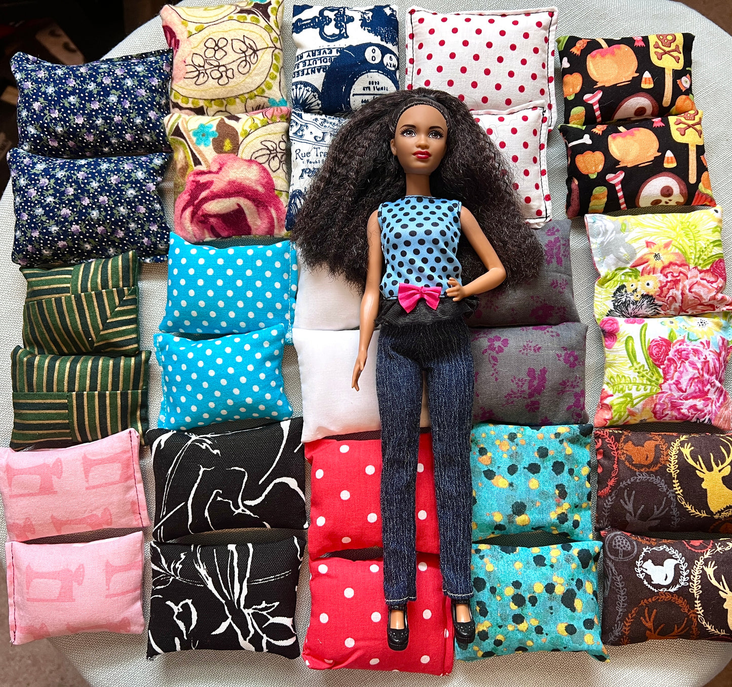 Barbie doll on a bunch of dollhouse pillows