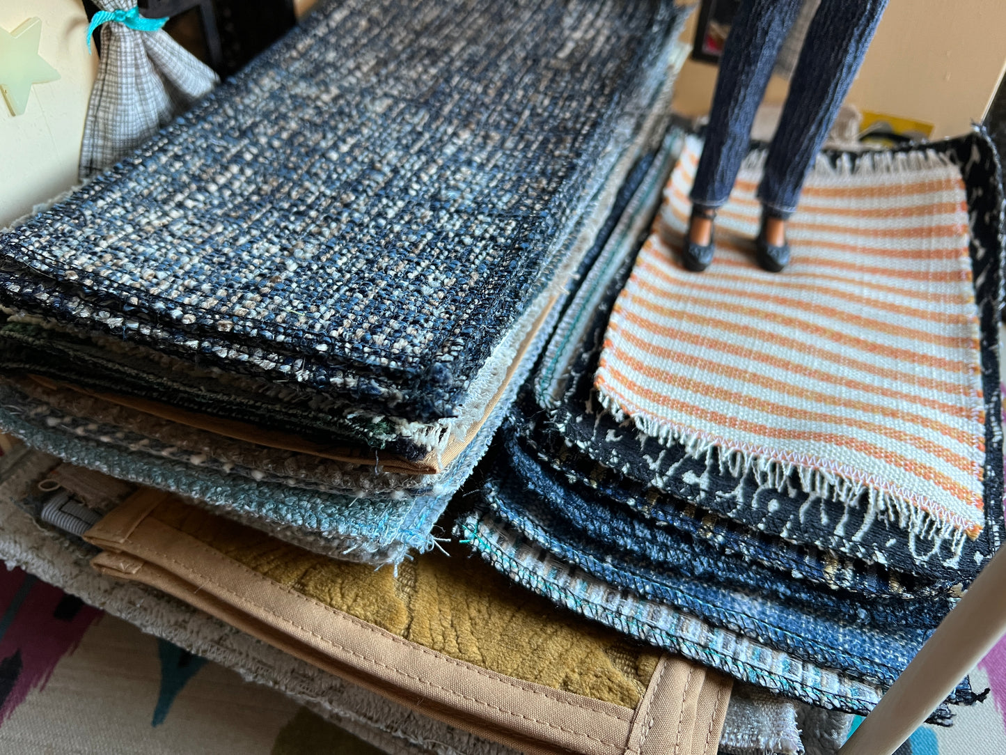 Stack of various textured fabric samples on a table.