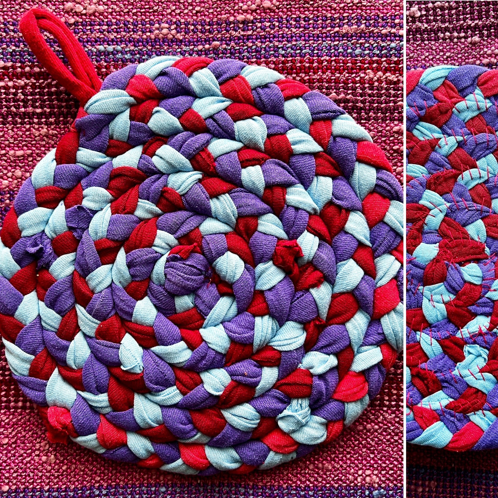 Round braided trivet with red, purple, and white pattern on a textured fabric background