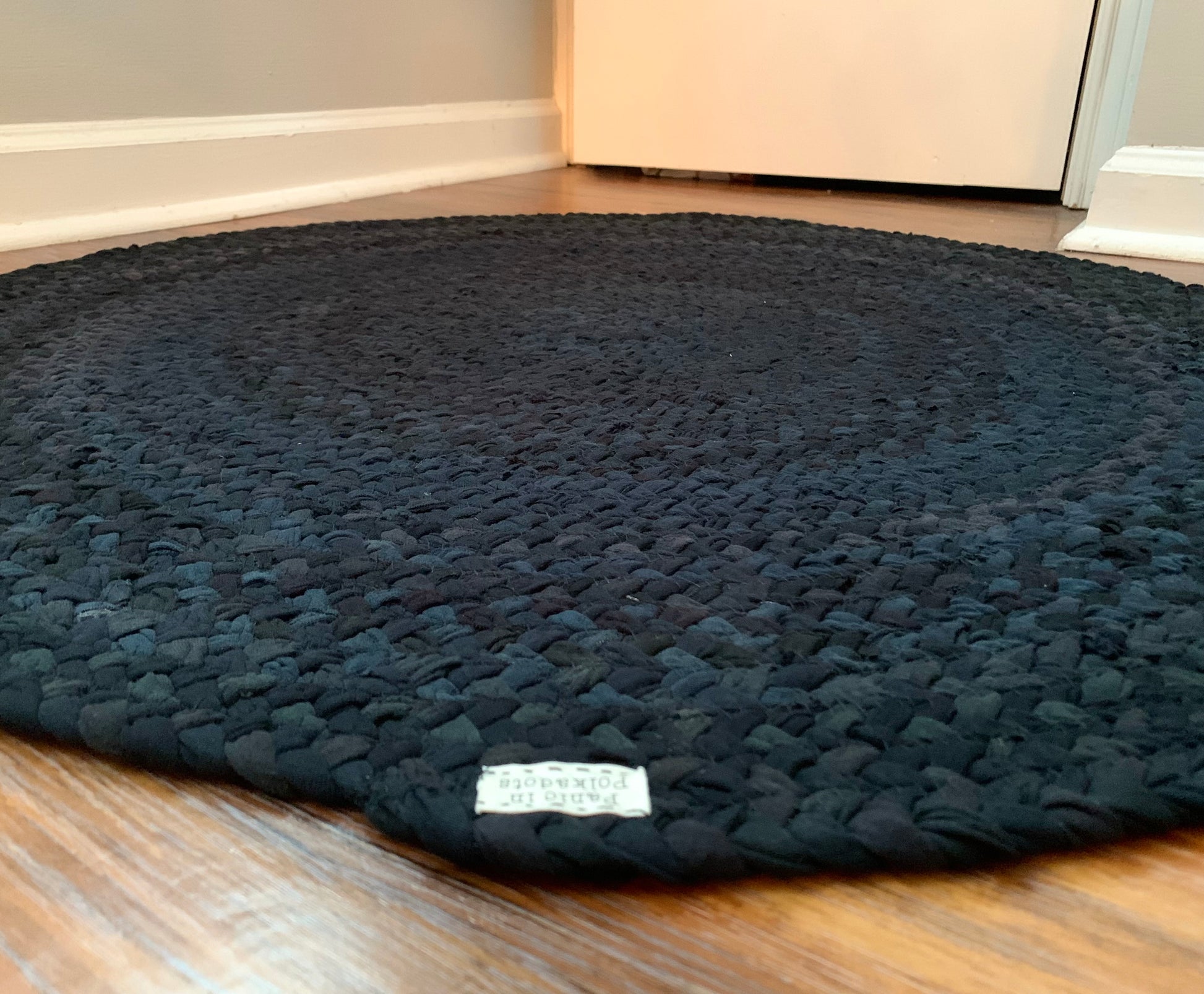 side view of underside of rug, showing Panic in Polkadots label and hand-stitching