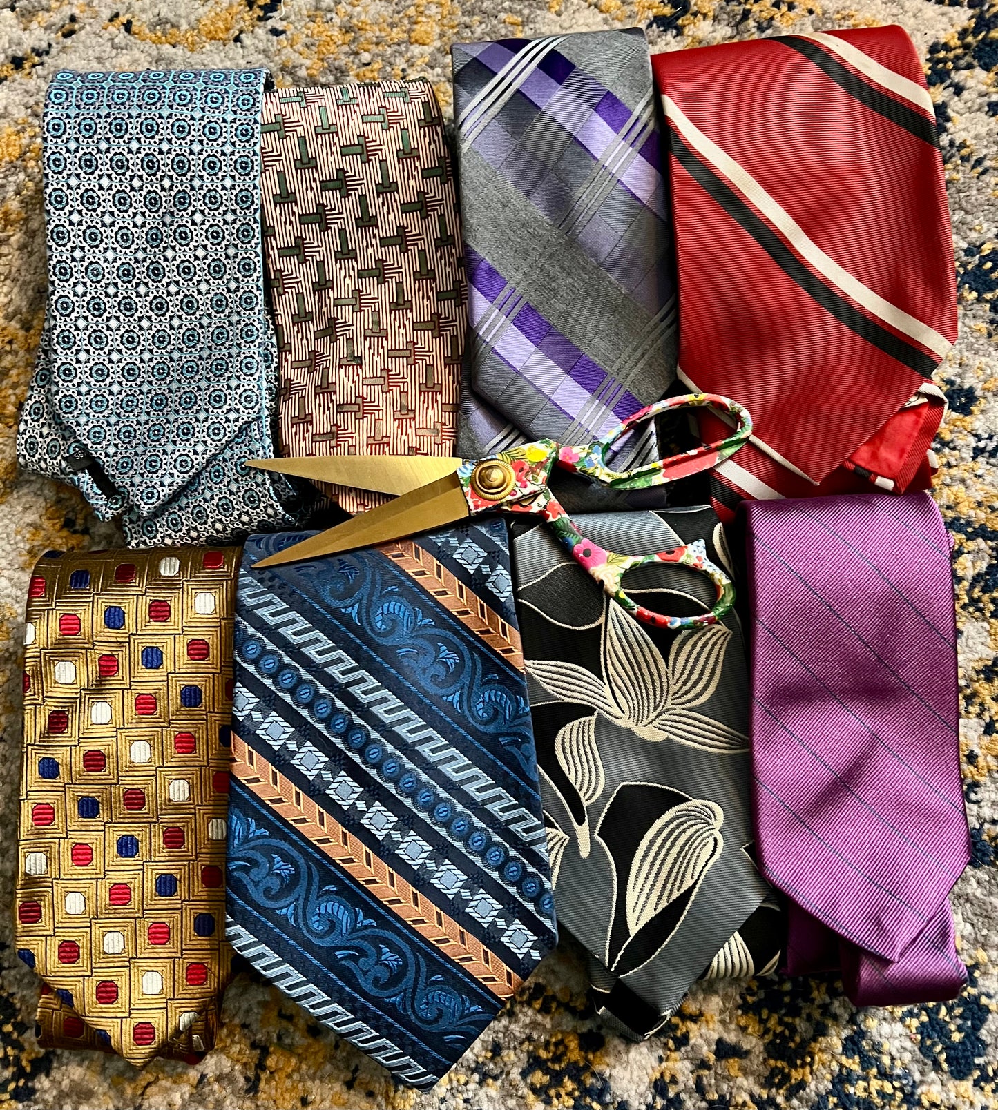 Collection of patterned ties and scissors on a textured surface