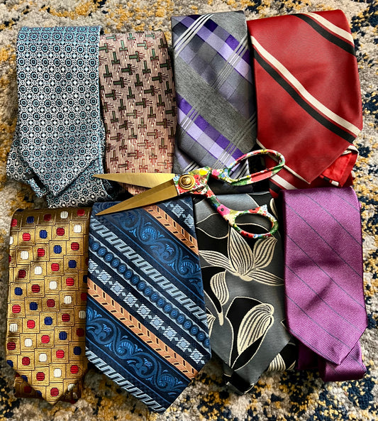 Collection of patterned ties and scissors on a textured surface
