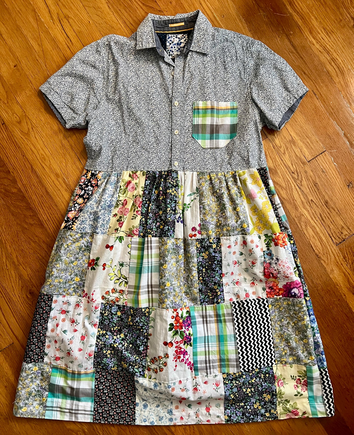 a patchwork shirt dress, with button-up top part, and patchwork shirt bottom part. on a wood floor background