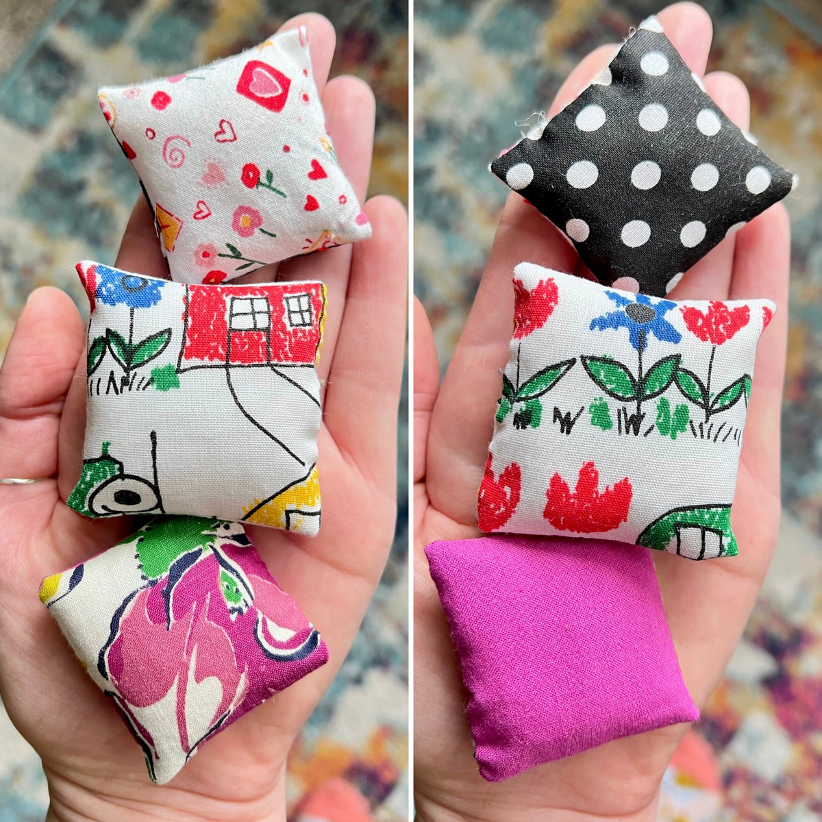 Collection of small fabric pillows with various patterns held in a hand.