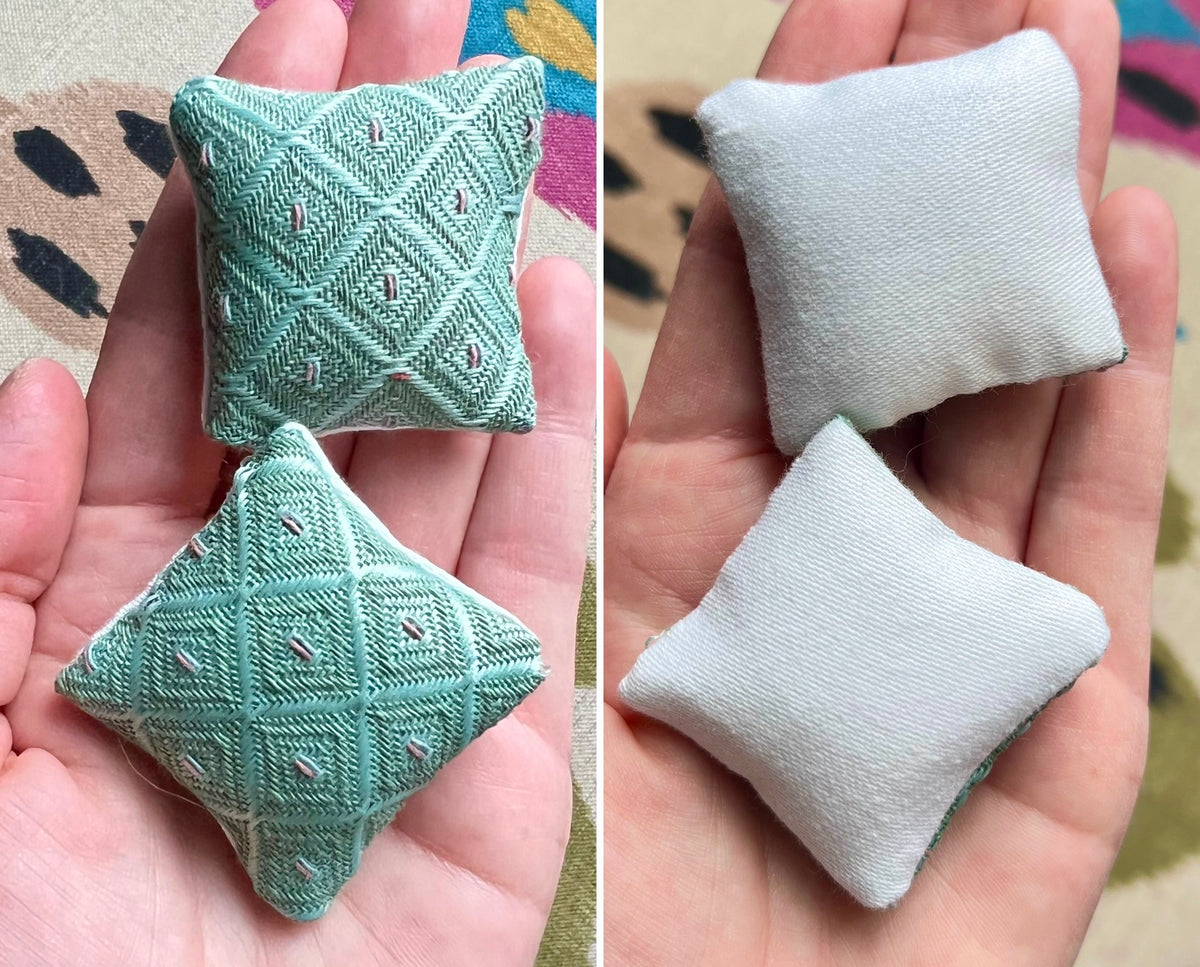 Two small fabric doll pillows, front green and back white, held in a hand against a colorful background.