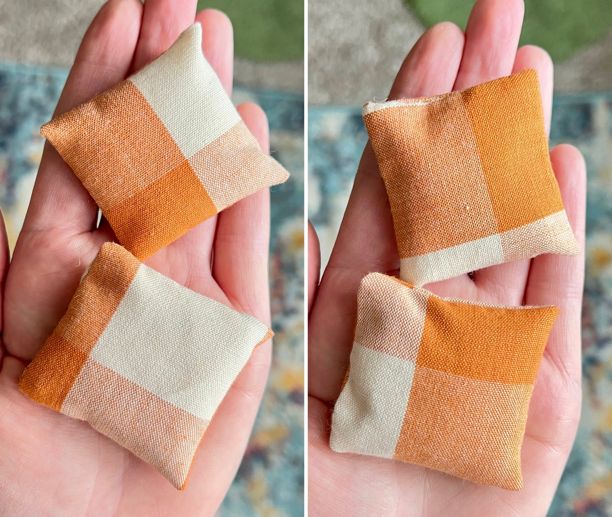 Two checkered fabric pillows held in hands with a blurred background