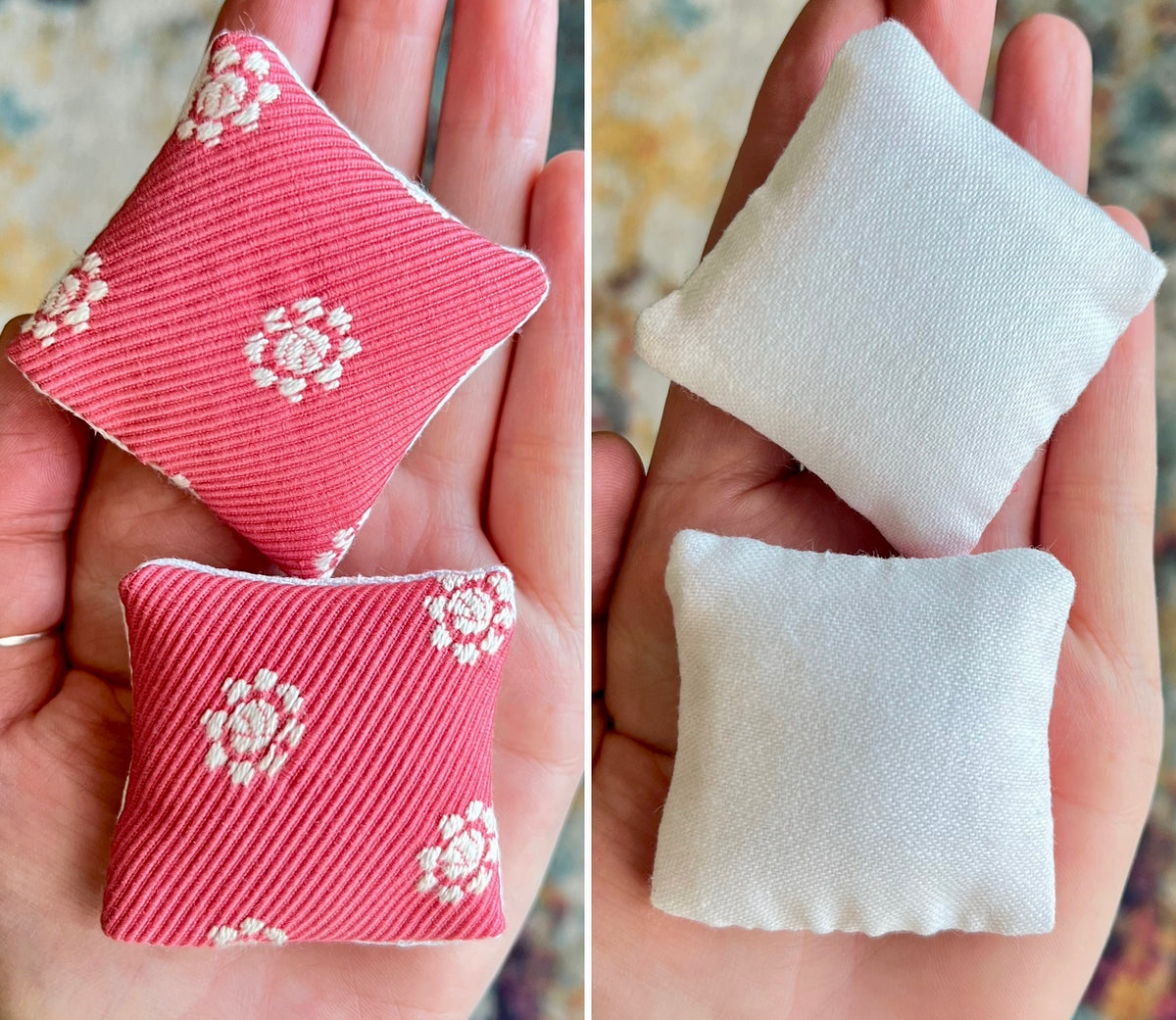Two small fabric doll pillows, front pink with floral patterns and back white, held in hands.