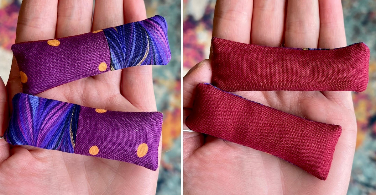 Two fabric doll pillows, front purple with gold polka dots and the back red, held in hands against a colorful background.