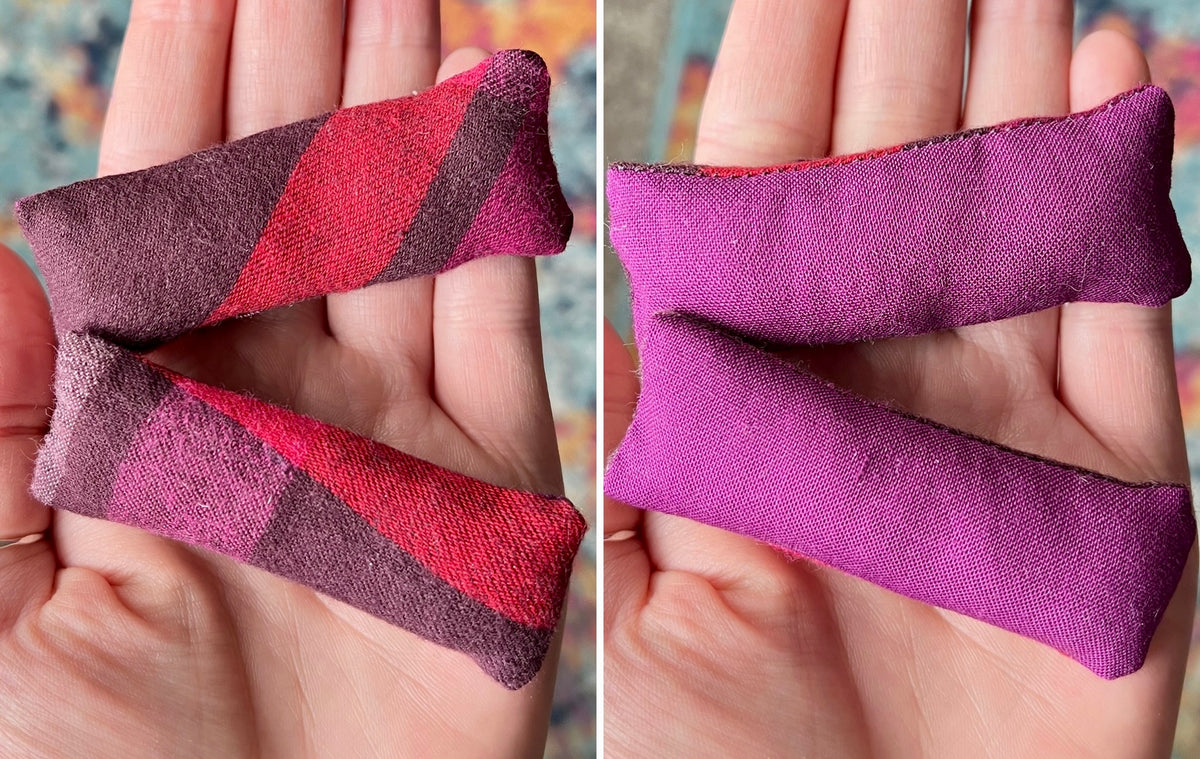 Two views of a purple and red striped fabric pillows held in hands for scale.